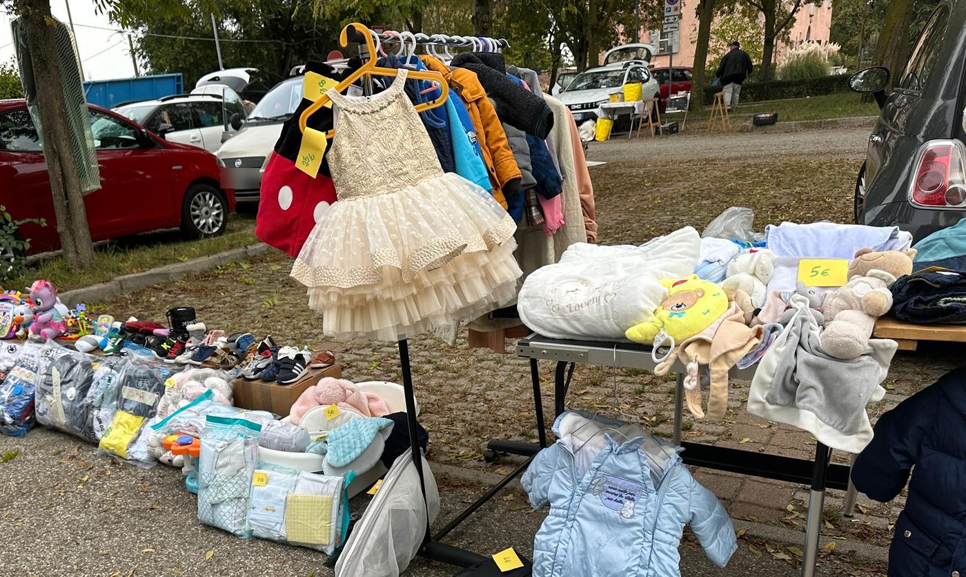 Un banco di vestiti e giochi per bambini, con un vestitino di tulle appeso allo stendino
